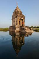 pequeno hindu têmpora dentro a meio do a piedosos narmada rio, maheshwar, madhya pradesh estado, Índia foto