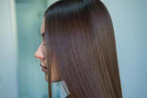 foto do uma europeu menina com grandes e lindo morena cabelo às a beleza salão. brilhante e saudável cabelo.