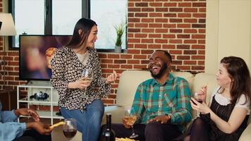 Hilário ásia mulher dizendo piadas às apartamento festa, fazer amigos rir. convidado fazer feliz bipoc grupo do pessoas risada dentro acolhedor casa enquanto bebendo álcool e comendo aperitivos foto