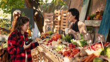 consumidor e ficar de pé suporte bebendo copo do quente café às agricultores mercado, mulher comprando fresco bio frutas e legumes. pequeno o negócio proprietário vendendo produtos e desfrutando Visita a partir de fiel cliente. foto