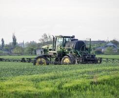 trator com uma spray dispositivo para finamente disperso fertilizante. foto