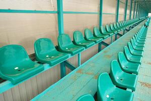 linhas do assentos dentro a esvaziar estádio. verde assentos às a estádio foto