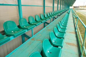 linhas do assentos dentro a esvaziar estádio. verde assentos às a estádio foto
