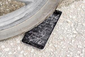 fechar-se Preto Móvel telefone acidente outono para a estrada e bater de motocicleta com vidro quebrado em estrada fundo. foto