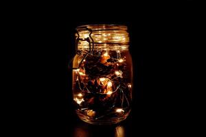 caloroso fada luz dentro uma vidro jarra, dentro a escuro, sutil fotografia foto