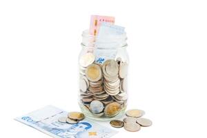 tailandês baht notas e moedas dentro uma vidro jar. o negócio e finança conceito. foto