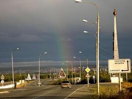 arco Iris sobre salekhard. a estrada às a Entrada para a cidade. foto