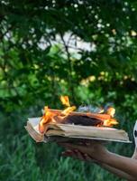 queimando livro dentro a mãos. queimando livros dentro a floresta. foto