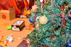 crianças brinquedos em a chão contra a fundo do a Natal árvore. foto