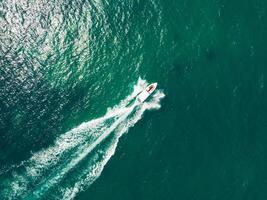 uma barco viajando através a oceano com uma despertar foto