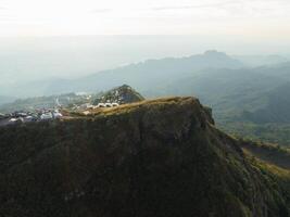 a aéreo Visão do uma montanha topo com uma pequeno casa em isto foto