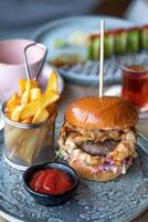 Hamburger com francês fritas e ketchup em uma de madeira mesa foto