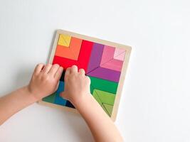 criança mão coleta multicolorido de madeira mosaico em branco fundo. foto