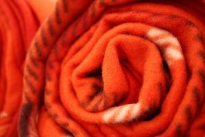 brilhante vermelho acolhedor lã cobertor enrolado acima foto
