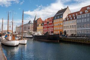 brilhante ensolarado dia às Nyhavn canal apresentando colorida moradias, copenhaga foto