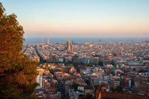 dourado hora sobre Barcelona com sagrada familia e Exemplo distrito foto