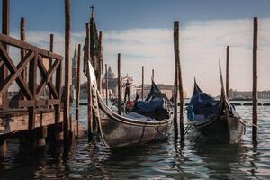 tranquilo Veneza gôndolas ancorado às sereno cais com obscuro água - pacífico italiano cena foto