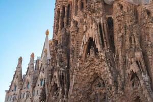 sagrada família intrincado fachada brilha dentro Barcelona em uma ensolarado dia foto