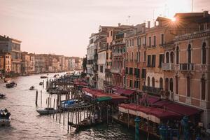 deslumbrante pôr do sol Visão do grande canal dentro Veneza, Itália com gôndolas e histórico arquitetura foto