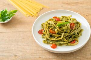 macarrão fettuccine espaguete com molho pesto e tomate foto