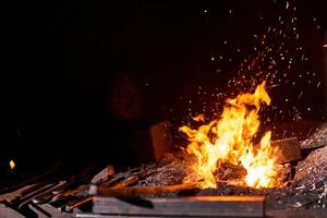 ferreiro forno com queimando fogo e forjamento Ferramentas deitado perto foto