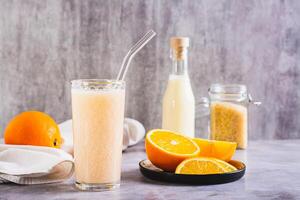 vegetariano batido fez a partir de arroz leite e laranja dentro uma vidro em a mesa foto