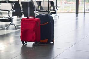 dois malas estão em a chão dentro aeroporto esperando quarto foto