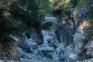 antigo romano ponte sobre uma sombrio desfiladeiro dentro a kesme bogazi desfiladeiro, Peru foto