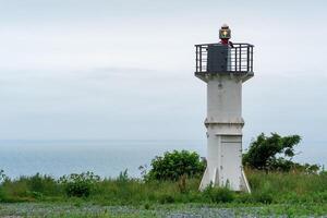 automático farol com setor luz em uma Alto capa acima a mar Porto foto