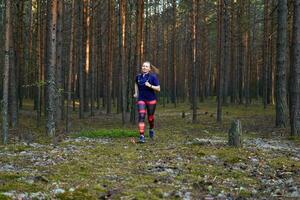 jovem mulher corrida dentro uma pinho floresta foto