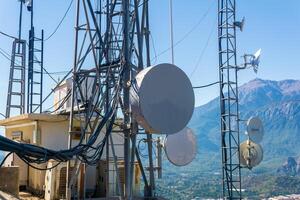 comunicação equipamento é instalado em uma telecomunicação torre dentro uma montanhoso área foto