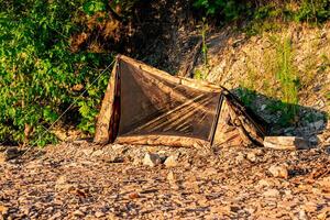 caminhar acampamento em uma rochoso costa, pequeno uma pessoa barraca foto