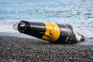estragado mar bóia - cardeal Perigo marca - lavado em terra depois de uma tempestade foto
