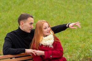 romântico jovem casal em uma parque Banco foto