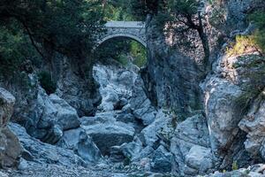 antigo romano ponte sobre uma sombrio desfiladeiro dentro a kesme bogazi desfiladeiro, Peru foto