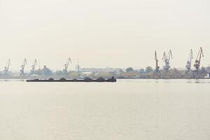 industrial rio paisagem aquática com seco carga barcaça e carga terminal dentro manhã névoa foto