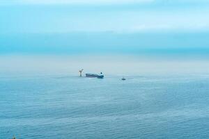 nebuloso marinha com uma petroleiro perto a óleo terminal localizado longe Fora para mar, topo Visão foto