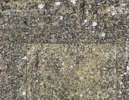 fundo, textura - uma parede do até rude pedra blocos, coberto com líquen a partir de velho era foto