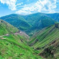 panorama do uma montanha vale dentro a Cáucaso com uma estrada cruzando isto foto