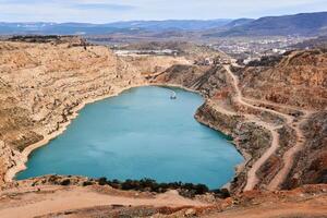 a aberto azul coração do a terra - abandonado pedreira com uma em forma de coração lago às a inferior foto