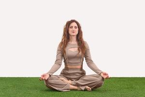 jovem mulher sentado dentro meditação pose em luz fundo foto