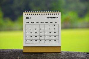 novembro 2024 branco calendário com verde borrado fundo. foto