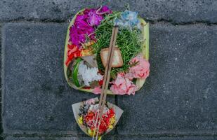 canang sári, balinesa ofertas em uma pedra muro. pequeno religiões oferta fez Fora do flores tradicional diariamente dentro bali ofertas. foto