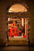 Natal fazer compras janelas do famoso moda marcas em a tarde rua do milão. moda distrito, milão butiques. compras e Natal feriados dentro Milão, Itália 12/05/2023 foto