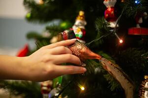 decoração Natal árvore, fechar acima, cópia de espaço. alegre Natal e feliz Novo ano. mulheres mãos decorar a Natal árvore com bolas e brinquedos foto