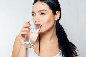 sorridente jovem mulher com vidro do água foto