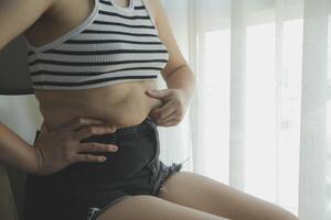 mulheres corpo gordo barriga. obeso mulher mão segurando excessivo barriga gordo. dieta estilo de vida conceito para reduzir barriga e forma acima saudável estômago músculo. foto