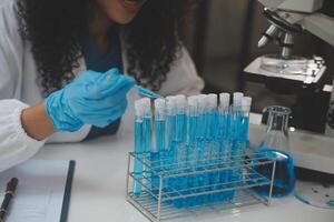 equipe de cientistas de pesquisa bioquímica trabalhando com microscópio para desenvolvimento de vacina contra coronavírus em laboratório de pesquisa farmacêutica, foco seletivo foto