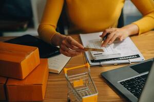 jovem mulher segurando uma Smartphone, tábua mostrando Forma de pagamento sucesso e crédito cartão com amarelo parcela caixa Como conectados compras conceito dentro escritório foto