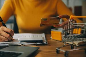 jovem mulher segurando uma Smartphone, tábua mostrando Forma de pagamento sucesso e crédito cartão com amarelo parcela caixa Como conectados compras conceito dentro escritório foto